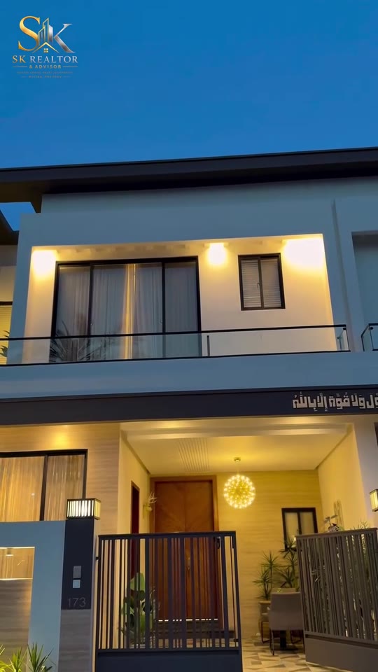 Modern two-storey house at dusk with warm exterior lights, from a property tour video